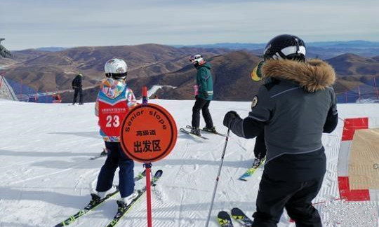 崇礼太舞滑雪场，小滑雪者在教练的带领下即将从高级道滑下。