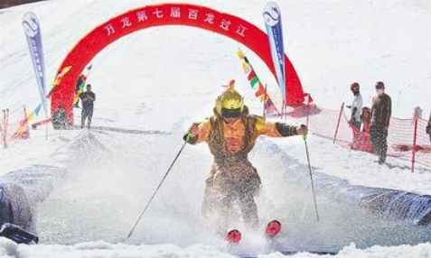 5月1日，万龙滑雪场第七届“百龙过江”活动现场，一名选手滑过水池。