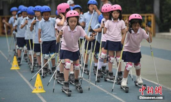 北京市中关村第三小学的学生们在校园内体验旱地越野滑雪